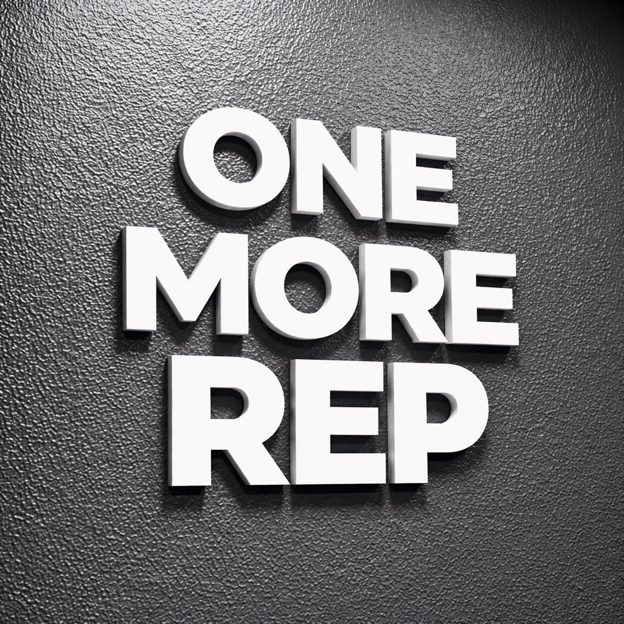 White 3D text on a textured dark gray background reads "ONE MORE REP." The letters are bold and stand out, creating a motivational message. The image is a close-up, emphasizing the text's prominence.